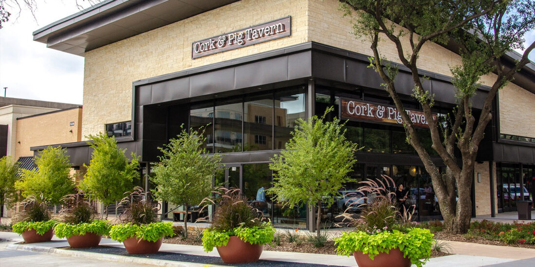 The exterior of Cork and Pig restaurant with a contemporary design, featuring large glass windows, and stylish signage.