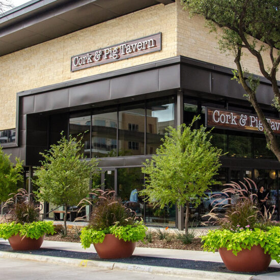 The exterior of Cork and Pig restaurant with a contemporary design, featuring large glass windows, and stylish signage.
