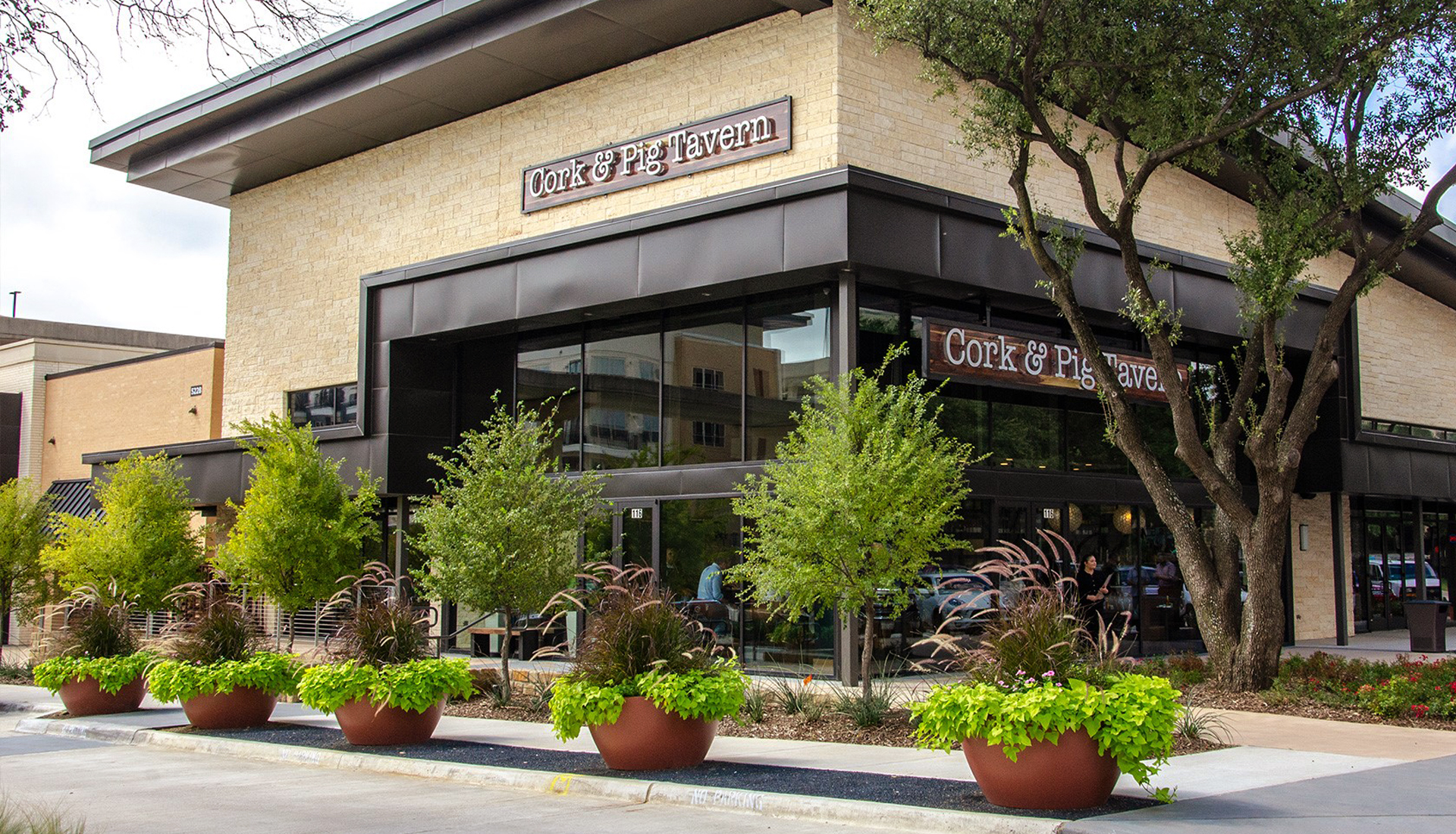 The exterior of Cork and Pig restaurant with a contemporary design, featuring large glass windows, and stylish signage.